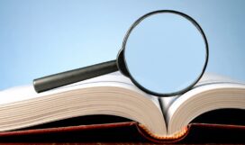 book and a magnifying glass on a blue background magnifying glass and an open book on a table