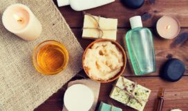 close up of body care cosmetic products on wood beauty, spa, therapy, natural cosmetics and wellness concept - close up of body care cosmetic products on wood