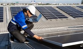 Asian technician installing inspection or repair solar cell panels on background field of photovoltaic solar panels solar cells on roof top factory. Asian technician installing inspection or repair solar cell panels on background field of photovoltaic solar panels solar cells on roof top factory.