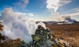 Namafjall Hverir geothermal area in Iceland. Aerial view Namafjall Hverir geothermal area in Iceland. Stunning landscape of sulfur valley with smoking fumaroles and blue cloudy sky, travel background, tourist attraction
