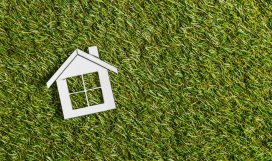 top view of white paper house on green grass, energy efficiency at home concept top view of white paper house on green grass, energy efficiency at home concept